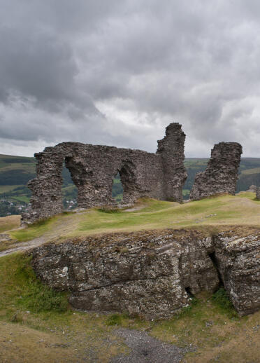 Ancient stone ruins of Castell Dinas Bran framed by a gloomy sky.