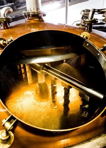 The inside of a golden vat brewing whisky.