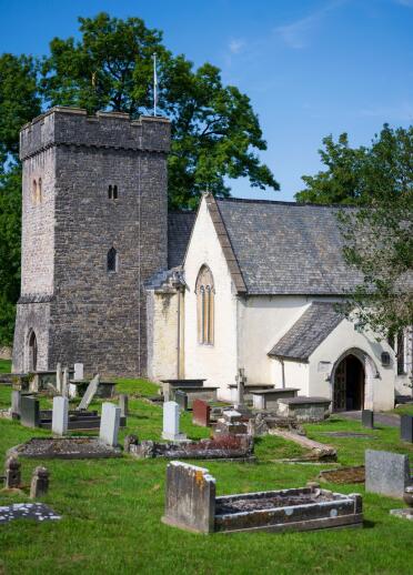 A church and tower behind a graveyard.