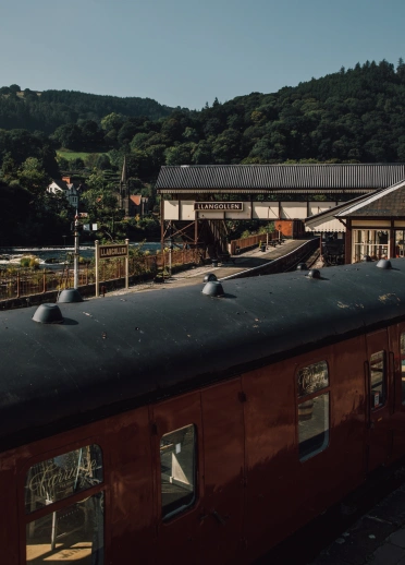 The carriage of a steam train at a station with the river flowing beside.