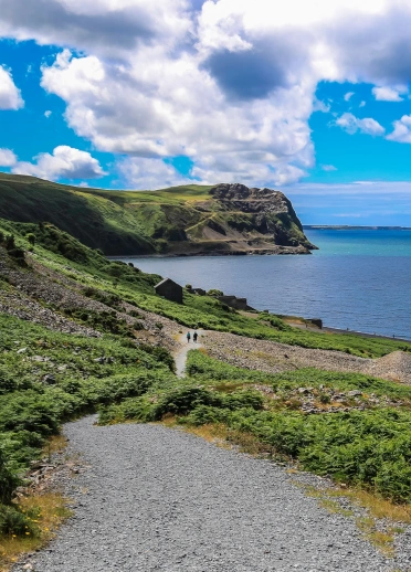 People walking along a coastal path with dramatic views.