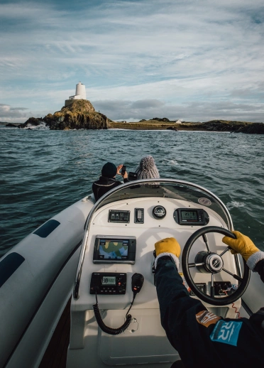 A speed boat heading toward a lighthouse.