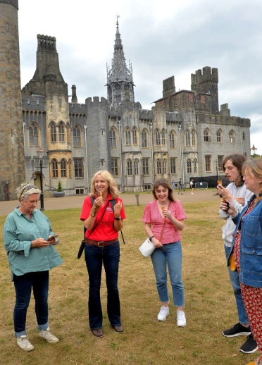 Group of people eating ice cream inside the grounds of a castle.