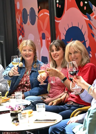 A group of people enjoying wine and laughing.
