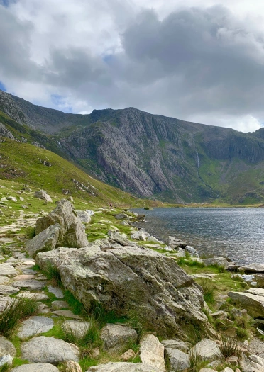 A lake surrounded by a rocky cove and mountains.