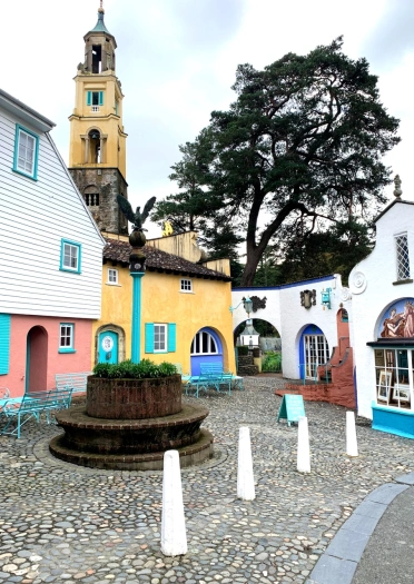 A colourful village of italianate architecture with a prominent bell tower.