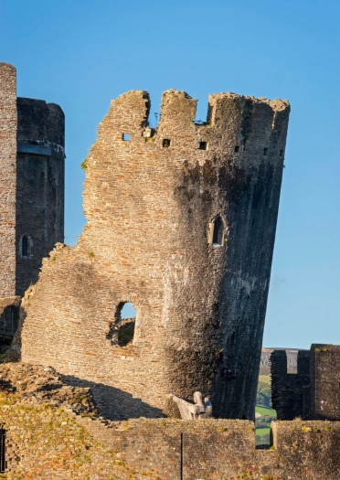 The leaning tower of a castle held up by a wooden statue inside the castle walls.