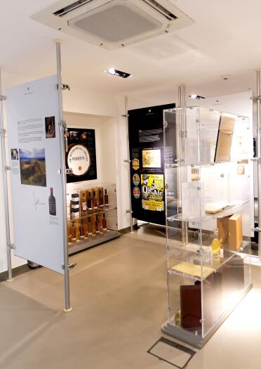 Items displayed in glass cabinets and artwork in the exhibition at Penderyn Distillery.