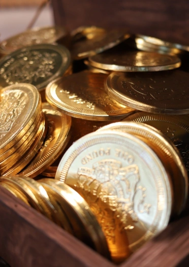 Brand new sparkling one pound coins in a wooden chest.