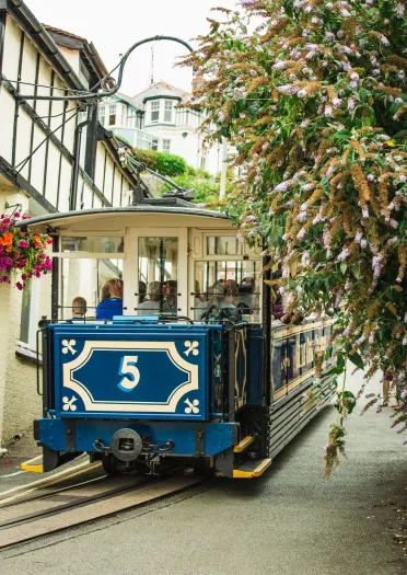A tram heading up a street.