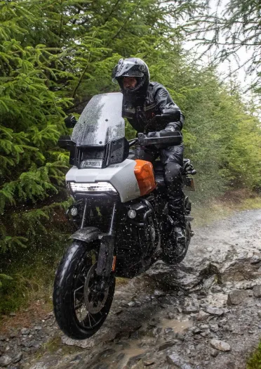 A biker on a motorcycle wearing full safety gear driving along a track.