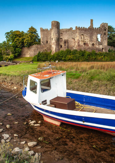 A castle with a boat in the foreground.