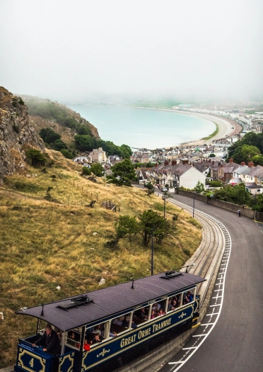 View of the Great Orme Tramway on a steep hill looking down to the sea.