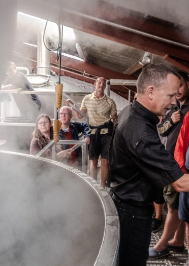 A group of people taking a tour around Purple Moose: brewery.