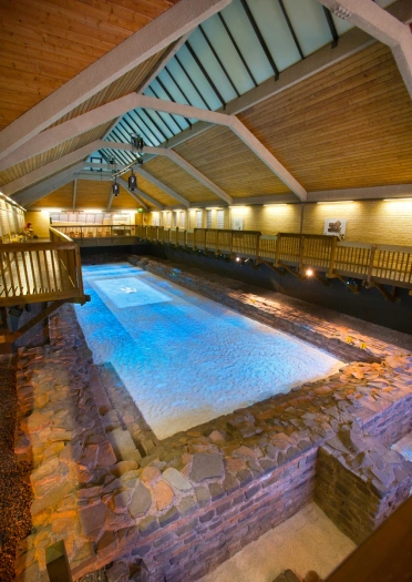 Indoor Roman bathing pool with a walkway above.