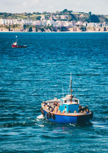 A boat travelling back from an island to the mainland with visitors.