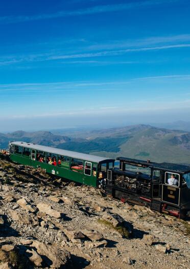 A steam train climbing a mountain.