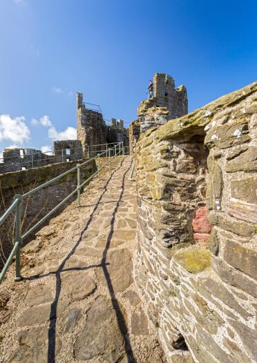 Castle town walls walkway leading towards a turret.