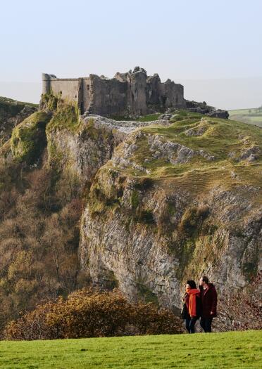 The ruins of a castle sitting dramatically on a cliff.