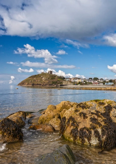 View of a castle on a hill from the coastline.