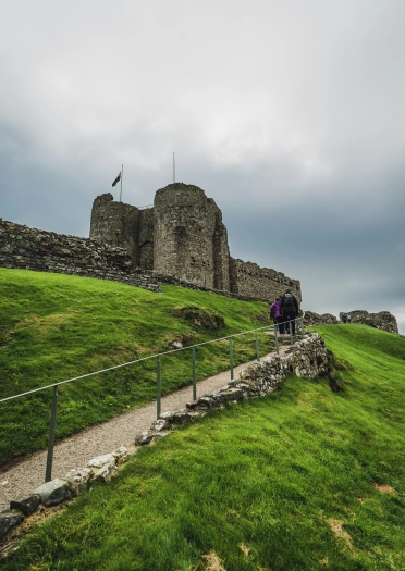 People walking up a hill toward a castle.