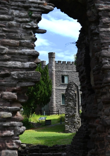 View of a museum from the hole in a stone wall of a castle.