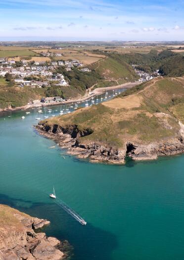 Aerial shot of a curved cove leading to a pretty harbour.