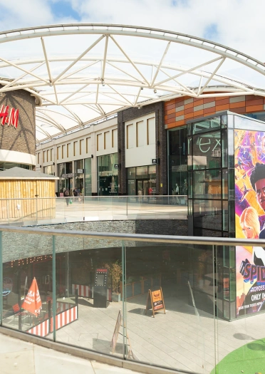 Two levels in a shopping arcade with eateries and shops.