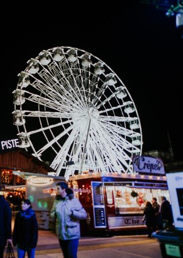 A big wheel and food stalls in a winter wonderland