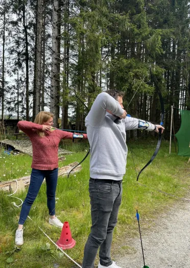 Two people taking part in an archery activity.
