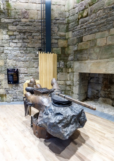 Iron statue of a glove holding bellows and a casket of coal.