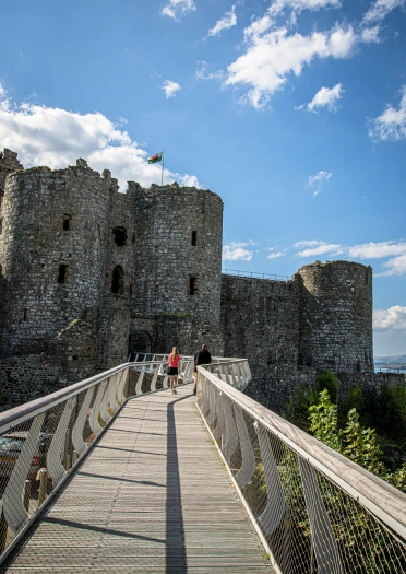 Couple on a floating bridge leading toward the entrance of a castle.