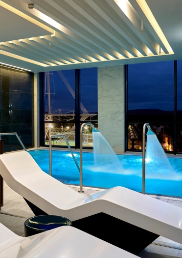 Relaxation beds next to a pool in a spa at a hotel.