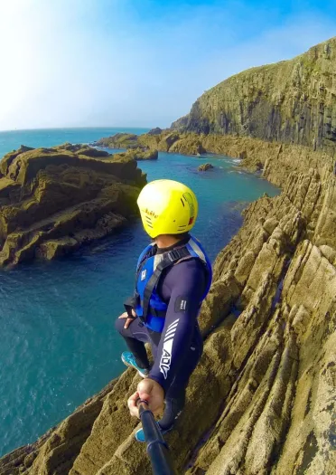 Coasteering on a rockface looking out to sea.