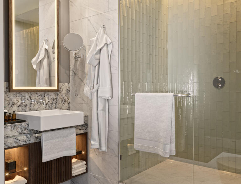 A modern shower room complete with towels and bathrobe.