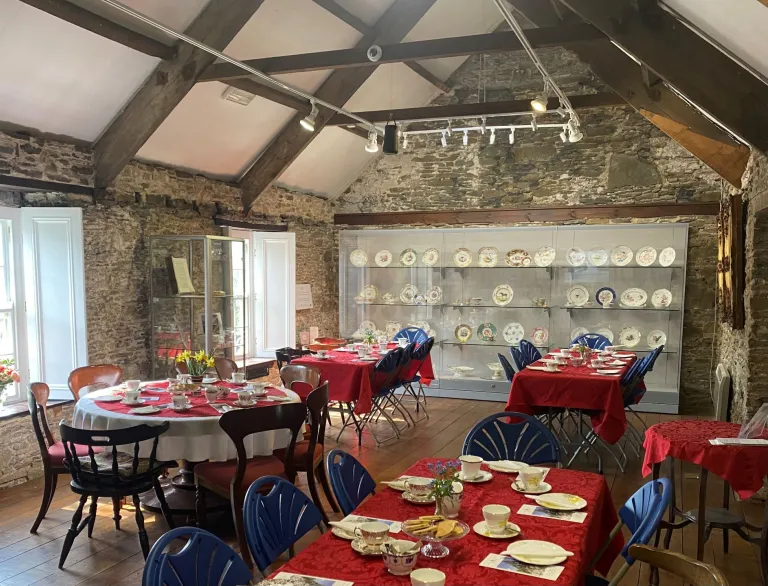 A dining room with displays of china plates in a glass cabinet.