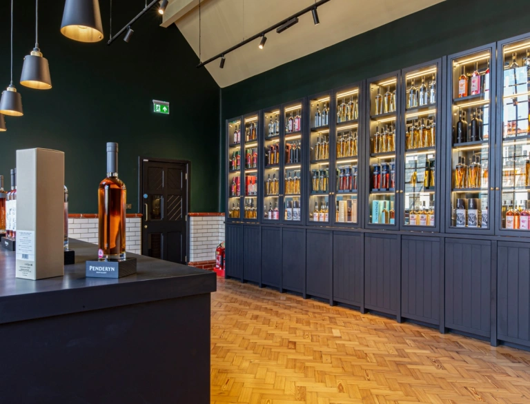 Bottles of whisky in cabinets and on a bar.