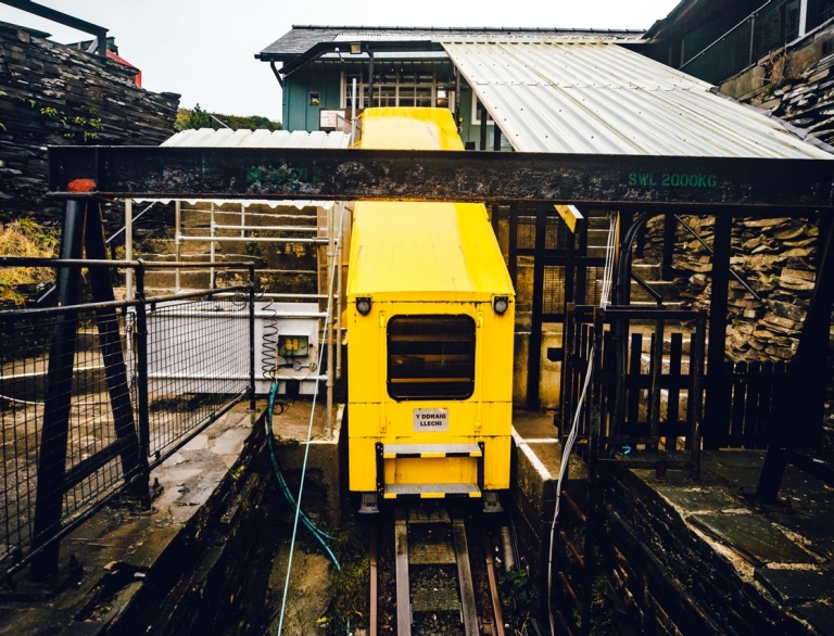 A cable car embarking on its journey into a slate cavern.