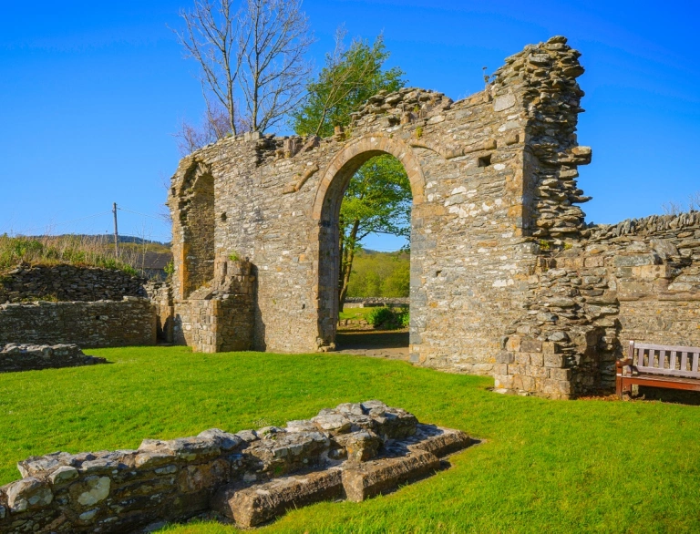 An arched doorway on the ruins of an abbey.