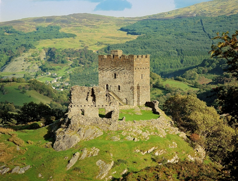 A castle on a large hill surrounded by countryside.