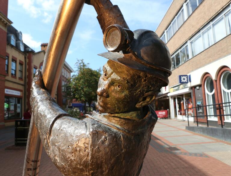 Bronze statue of a miner in a city centre