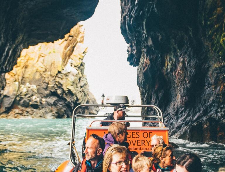 A group of people in a boat going through an ocean cave.