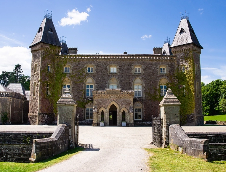 A walled entrance leading to a grand mansion.