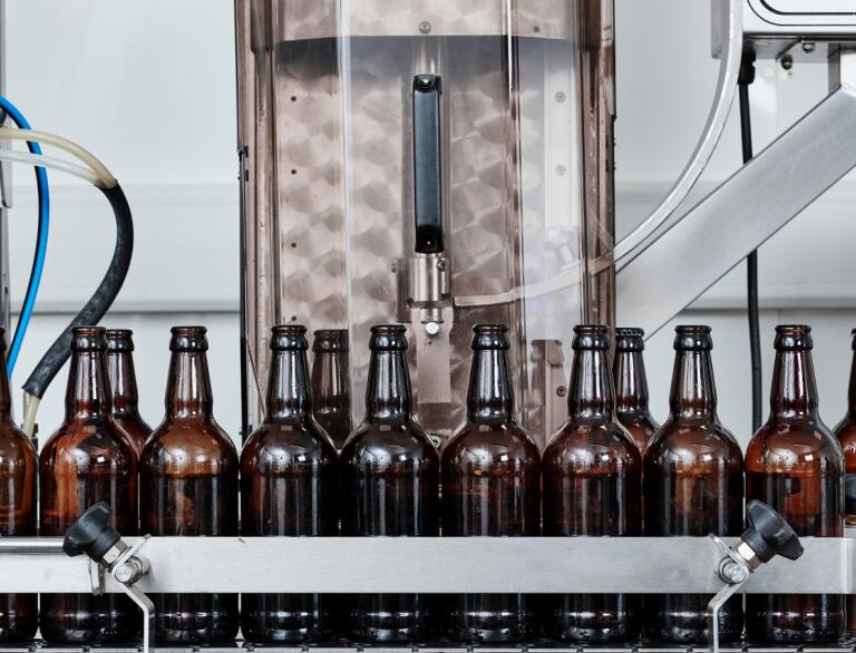 Rows of bottles on a conveyor belt in a brewery.