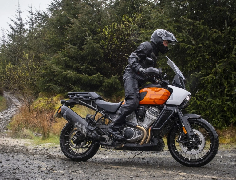 A biker on a motorcycle wearing full safety gear driving along a track.