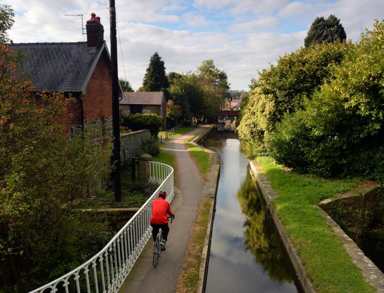 A man cycling along the footpath alongside the Montgomery Canal near Welshpool.