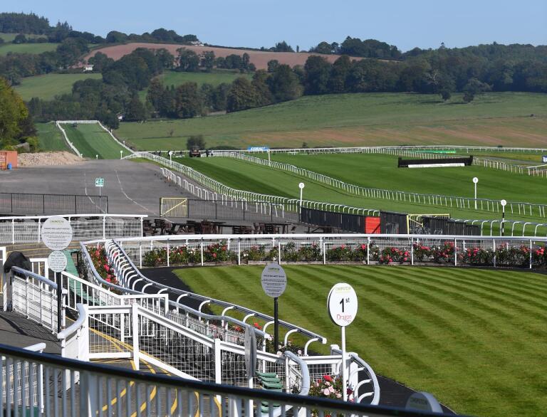 View of the race track at a racecourse for horses on a sunny day.