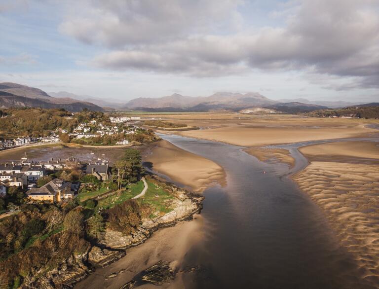 Aerial shot of sand banks, coastline and mountains.