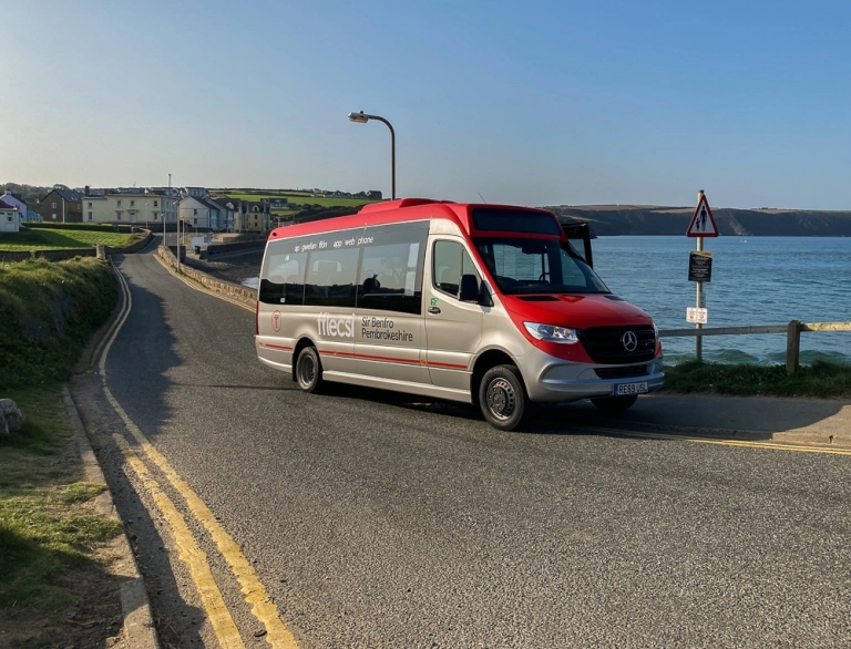 Minibus travelling along the coast road.