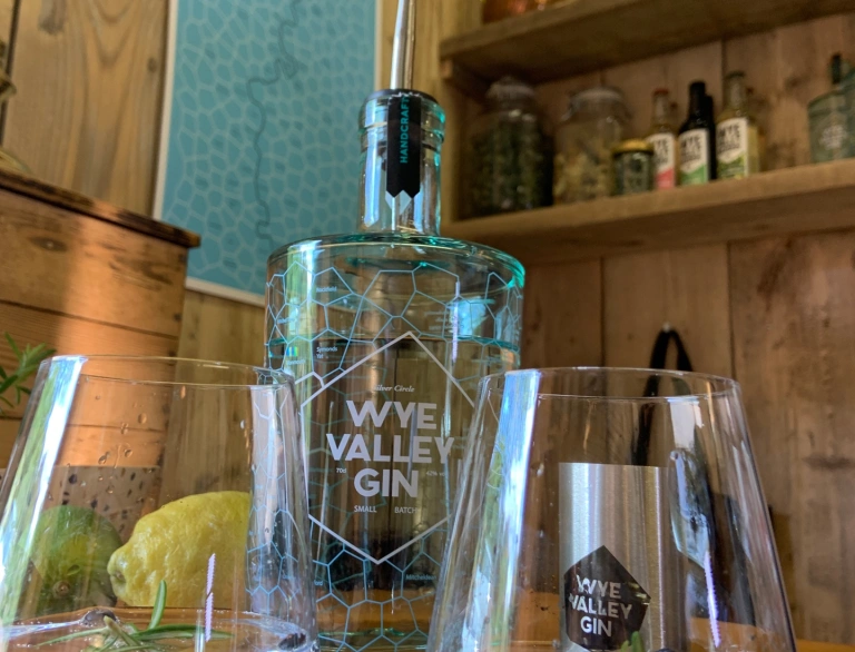A bottle of gin and glass on a table at a distillery.
